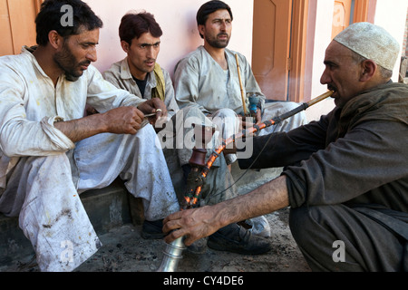 Wazas, traditionellen Kashmiri Köche nehmen eine Pause Rauchen eine Wasserpfeife in ein Wazwan, ein Kashmiri fest, Srinagar, Kaschmir, Indien Stockfoto