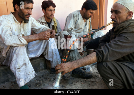 Wazas, traditionellen Kashmiri Köche nehmen eine Pause Rauchen eine Wasserpfeife in ein Wazwan, ein Kashmiri fest, Srinagar, Kaschmir, Indien Stockfoto