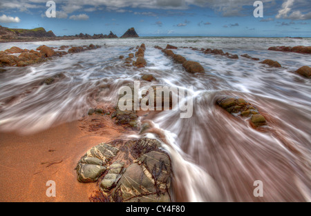 Die Flut an diesem malerischen noch dramatisch zerklüfteten Strand am Hartland Quay an der Nordküste von Devon Stockfoto