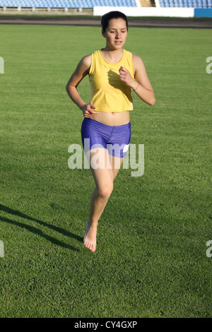 Schöne Teenager Sport Mädchen laufen auf dem Rasen. Stockfoto