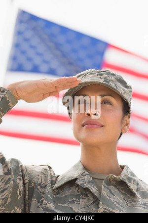 USA, New Jersey, Jersey City, weibliche Armee Soldaten salutieren, amerikanische Flagge im Hintergrund Stockfoto