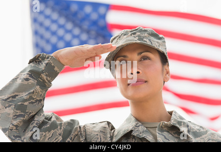 USA, New Jersey, Jersey City, weibliche Armee Soldaten salutieren, amerikanische Flagge im Hintergrund Stockfoto