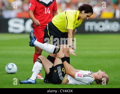 Simone Laudehr Deutschlands hält ihr Bein als Schiedsrichter sieht Jacqui Melksham während das Eröffnungsspiel der Frauen WM auf. Stockfoto