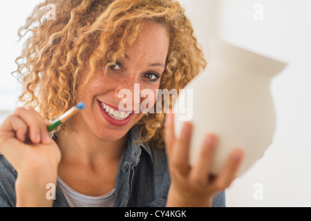 USA, New Jersey, Jersey City, Portrait der Künstlerin Malerei auf Keramik im studio Stockfoto