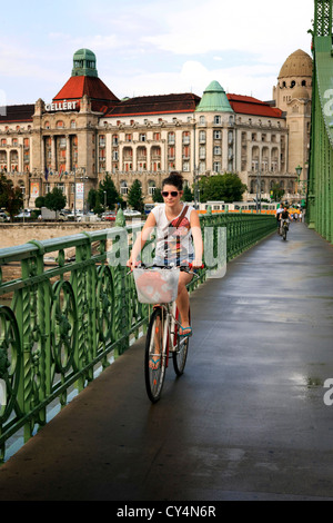 Frau mit dem Fahrrad durchquert die Donau über die Brücke der Freiheit Stockfoto