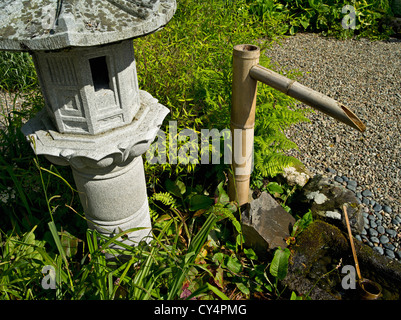 Stein-Laterne und Bambus Wasserspiel in einem japanischen Garten in Schottland nw. Stockfoto