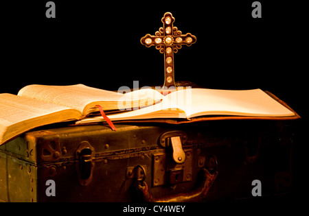 Vintage, antike religiöse Gegenstände gemalt mit Licht. Missionarische Elemente wie eine Bibel, Zeitschrift, Koffer und Kreuz Stockfoto