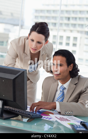 Porträt eines Business Teams Statistik studieren, während der Verwendung eines Computers Stockfoto