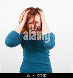 Studio gedreht, Portrait Frau hält ihren Kopf und schreien Stockfoto