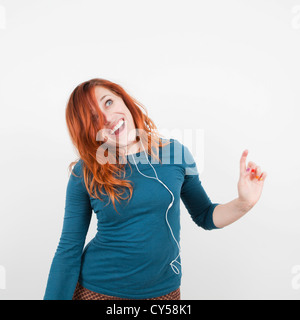 Studio gedreht, Porträt von lächelnden Frau anhören von Musik Stockfoto