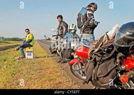 Indische Motorradfahrer Rast bei den 153 Kilometern, Indore Meilenstein auf die NH3-Mumbai nach Agra Straße unterwegs. Stockfoto