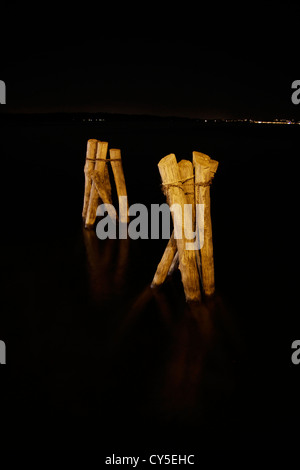 Holzboot Liegeplatz Beiträge in See in der Nacht Stockfoto