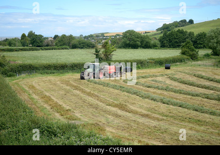 BAUERNHOF TRAKTOR PRESSEN SILAGE IM VEREINIGTEN KÖNIGREICH Stockfoto