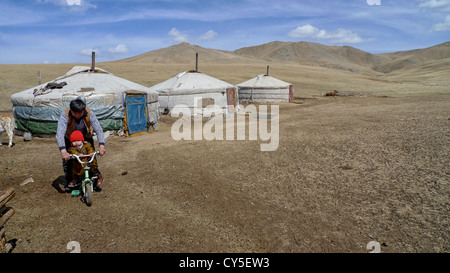 Ein Vater seinen Sohn auf einem Fahrrad schieben. Bild in der Mongolei. Stockfoto