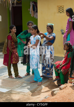 Indian Mother Bürsten und Flechten Töchter Haar für Dasara Festival in einem indischen Dorf. Andhra Pradesh, Indien Stockfoto