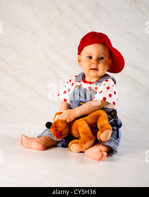 SECHS MONATE ALTES BABY MÄDCHEN MIT STOFFTIER Stockfoto