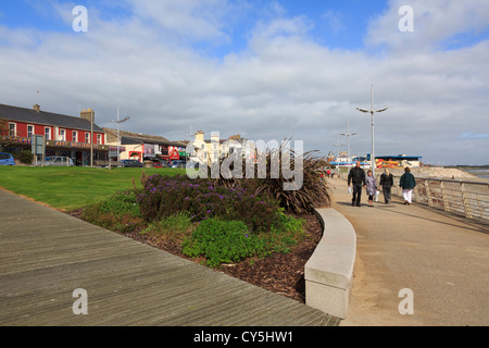 Menschen zu Fuß direkt an der Strandpromenade des Seebades an der Ostküste in Newcastle, Co Down, Nordirland, Vereinigtes Königreich Stockfoto