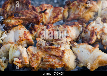 Saftige Scheiben von Fleisch mit Soße vorbereiten auf Feuer Stockfoto