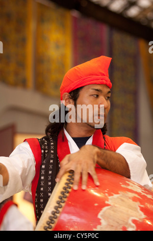 Ein männlicher Schlagzeuger führt einen traditionellen Tanz der Okinawa Ryukyu Village - ein Themenpark alten Okinawan Kultur gewidmet. Stockfoto