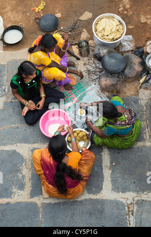 Indische Frauen und Mädchen machen süße Jagrezucker gefüllt Chapathi für Dasara Festival in einem indischen Dorf. Andhra Pradesh, Indien Stockfoto