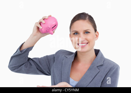 Banklehre bei der Sparschwein in der Hand lächelnd Stockfoto