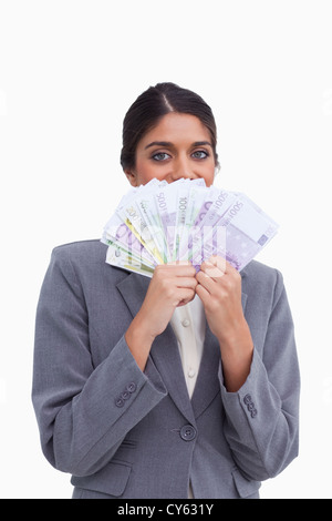 Unternehmerin, versteckt ihr Gesicht hinter Banknoten Stockfoto