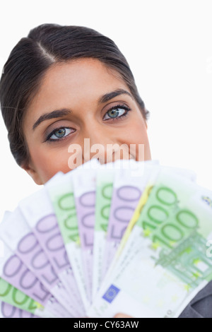 Nahaufnahme von Unternehmerin versteckt ihr Gesicht hinter Banknoten Stockfoto