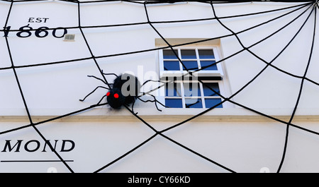 Großen künstlichen schwarzen Spinnen und Spinnweben an der Seite ein Juwelier-Geschäft in Whitby, North Yorkshire, England, uk befestigt Stockfoto