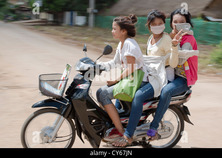 Drei Mädchen beschleunigen, indem Sie auf einem Motorrad in Sisophon, Kambodscha Stockfoto