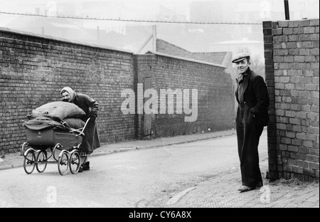 Frau schiebt einen Kinderwagen voller Koks aus Dudley Gas Works in Spring Gardens Dudley West Midlands 1953. Arbeiter Großbritannien 1950er Jahre britischer Arbeiter schwarzes Land Arbeiterklasse schlechter Lebensstil Armut Stockfoto