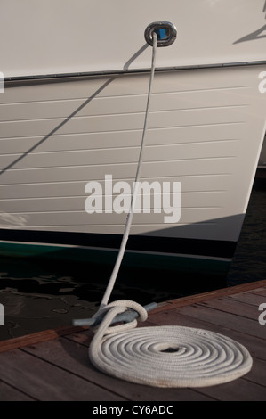 weißes Boot an einem Dock mit einem gewendelten weißen Link auf der Anklagebank Stockfoto