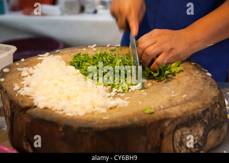 Mann, die Vorbereitung, Zwiebeln und Koriander serviert mit Carnitas in Tacos auf Jamaika Markt in Mexiko-Stadt DF Stockfoto