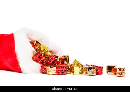 kleine bunte Weihnachtsgeschenke fallen von Santas Hut auf weißem Hintergrund Stockfoto