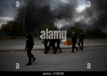 Polizei führt einen verletzten Kollegen für die Sicherheit während der Erstürmung der US-Botschaft in Tunis Stockfoto