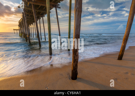 Cape Hatteras National Seashore, Avon, North Carolina Sunrise Reflexionen über Surf und Wellen unter dem Avon Fishing pier Stockfoto