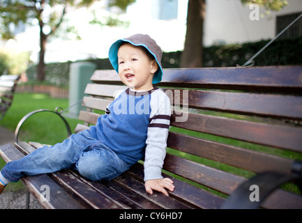 Glückliches asiatischen Kind sitzt auf dem Gartenstuhl, shanghai, china Stockfoto