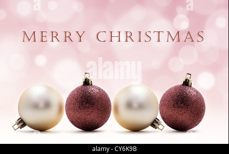 Weihnachtskarte - vier Weihnachtskugeln in Linie auf rosa Hintergrund Stockfoto