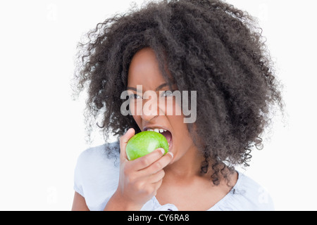 Junge Frau, die einen grünen Apfel zu essen Stockfoto