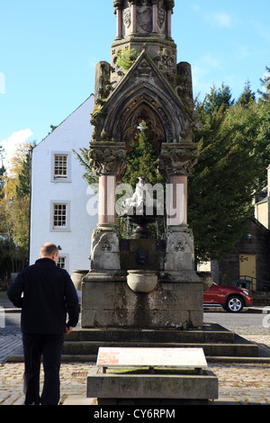 Dunkeld Perhshire - Mann, Blick auf die historische Informationen über Atholl Memorial Fountain am Kreuz oder Altstädter Ring Stockfoto