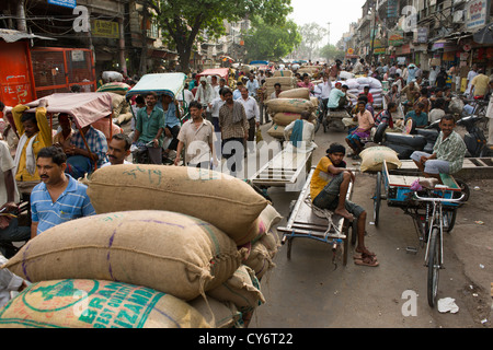 Porter, sitzt auf einem Handwagen unterwegs Khari Baoli (Markt Gewürzbasar aus Chandni Chowk), Alt-Delhi, Indien Stockfoto