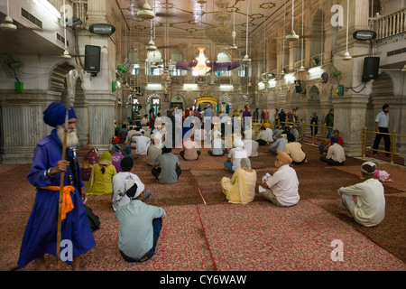 Sikh bewachen in der Hauptgebetshalle des Gurdwara Sis Ganj Sahib, ein Sikh-Tempel in Chandni Chowk, Alt-Delhi, Indien Stockfoto