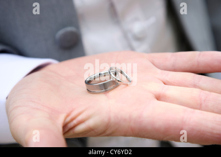 BestMan Trauringe in Handfläche am Hochzeitstag halten Stockfoto