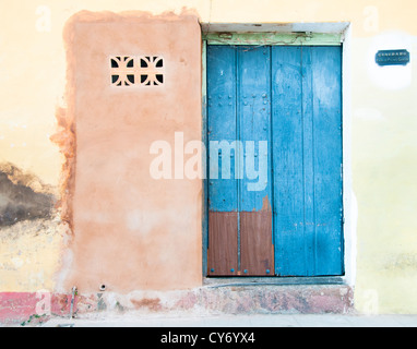 Blaue Holztür in Pastelltönen gestrichenen Wand in Trinidad, Kuba Stockfoto