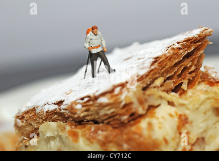 winzige Figur Wanderer auf der Torte Stockfoto