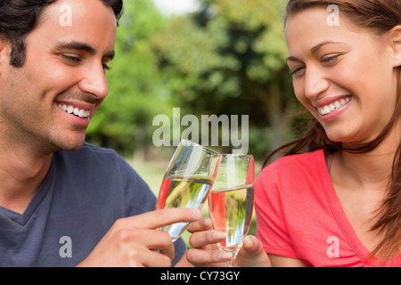 Zwei Freunde lächelnd wie sie Gläser Champagner zusammen in Feier berühren Stockfoto