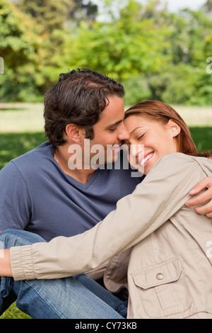 Mann lächelnd, als sein Freund den Kopf auf seinen Schultern ruht Stockfoto