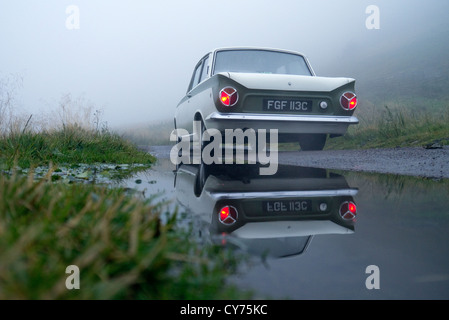 1965 Ford Lotus Cortina fahren auf einer englischen Landstraße Stockfoto