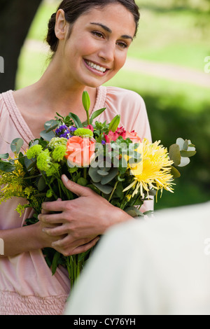 Frau mit Blumen, die sie gegeben hat Stockfoto