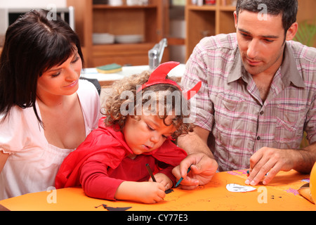 Kleiner Junge als Teufel verkleidet und Dekorationen vorbereiten Stockfoto