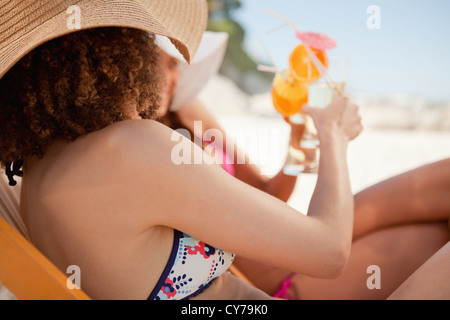 Seitenansicht der jungen Frauen, die ihre Gläser klirren Stockfoto